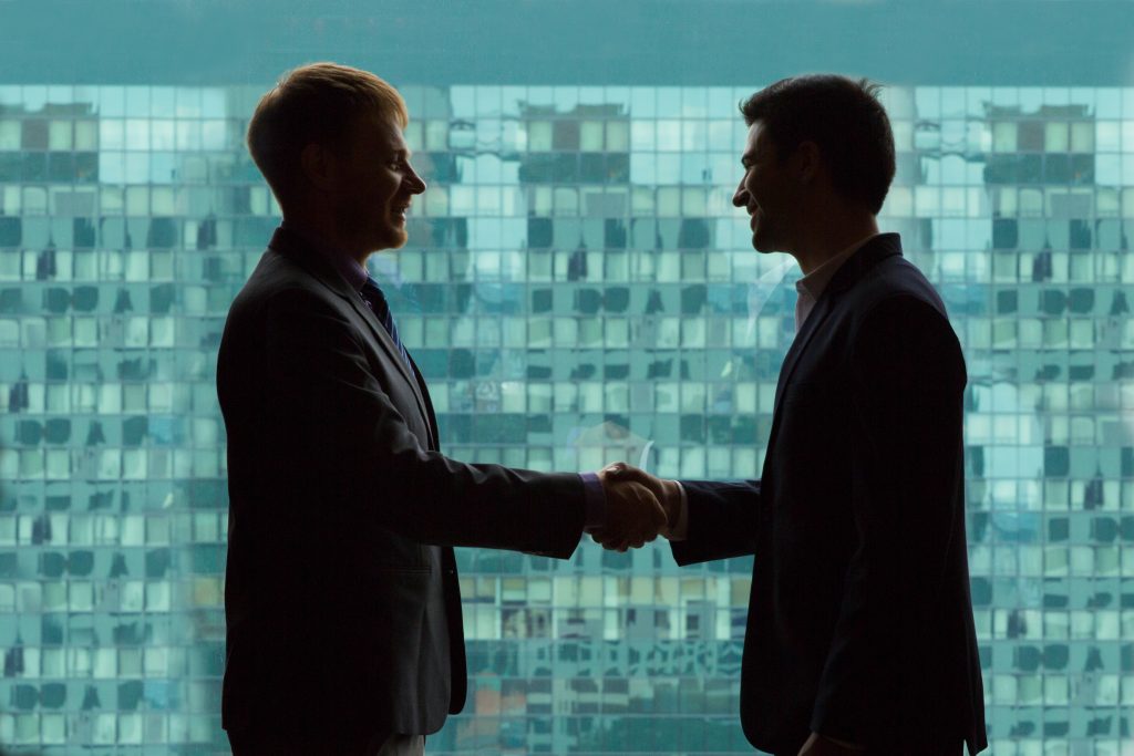 Silhouettes of Businessmen Shaking Hands